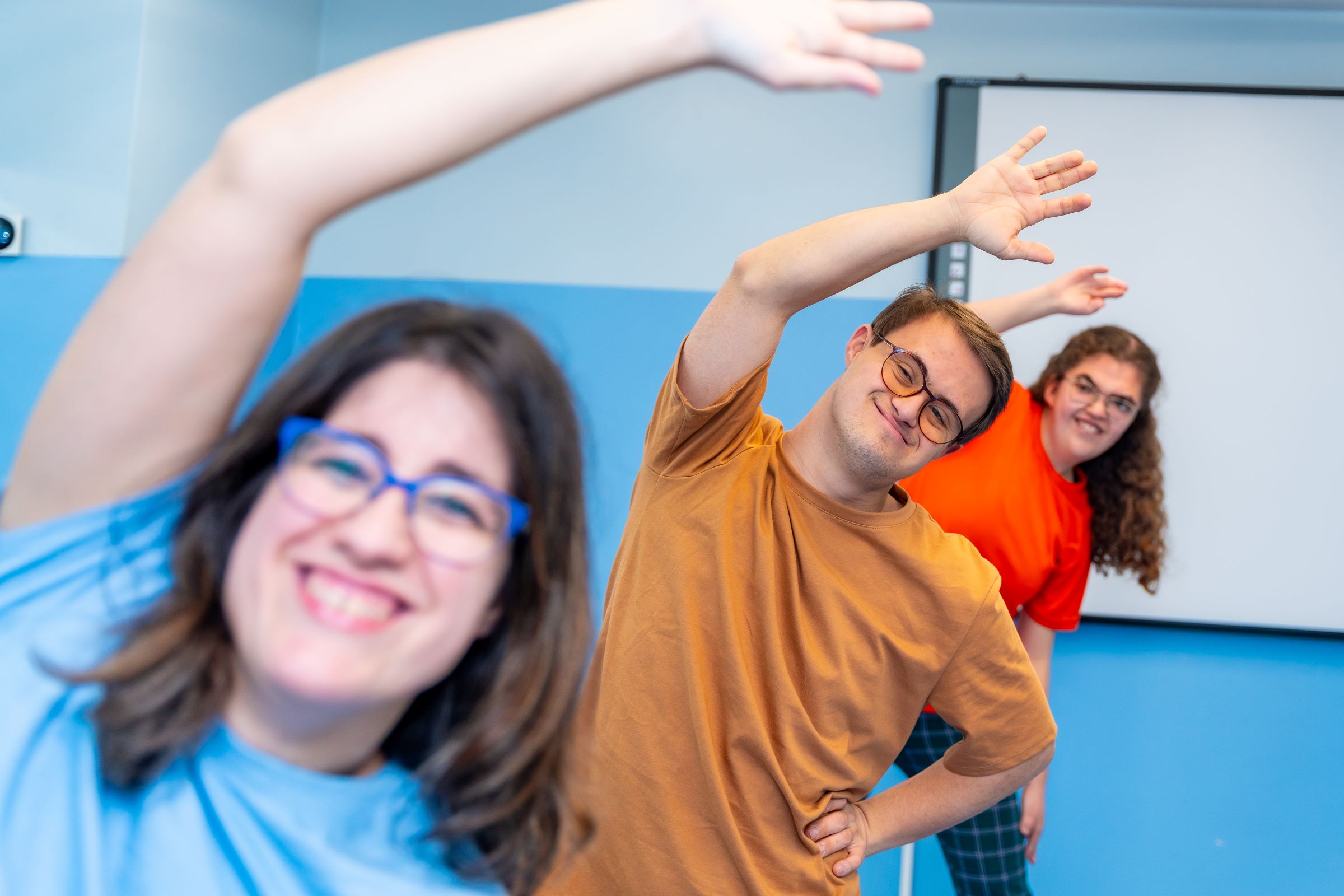 Three friends with developmental disabilities at a group home enjoying a gym class.